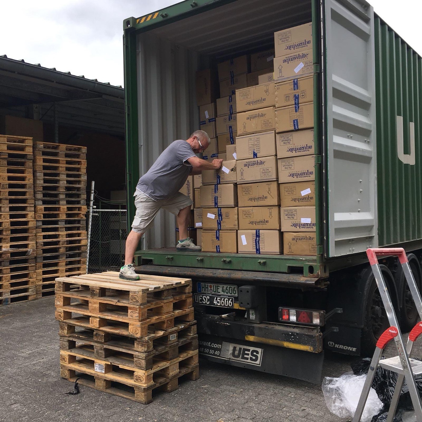 Entladung eines Sonderposten-Containers mit gestapelten Kartons in Hamburg